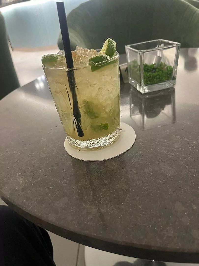 Mojito su tavolo con bicchiere sfondo verde.