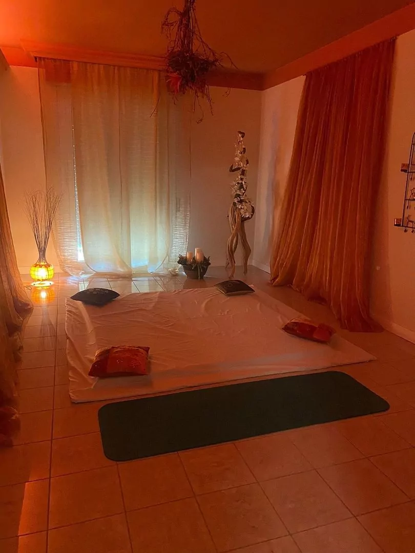 Ambiente rilassante per yoga o meditazione con luci soffuse.