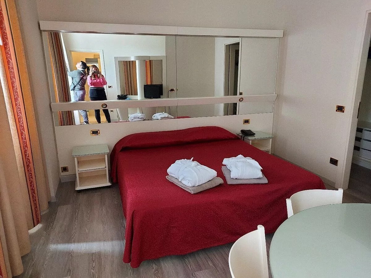 Camera da letto moderna con specchio e letto rosso.