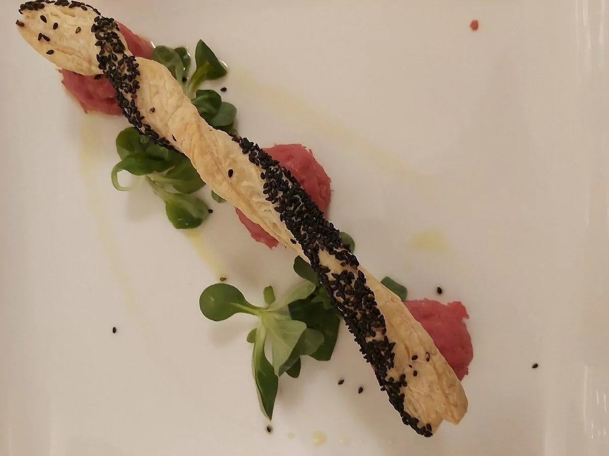 Piatto gourmet con grissino sesamo e insalata.