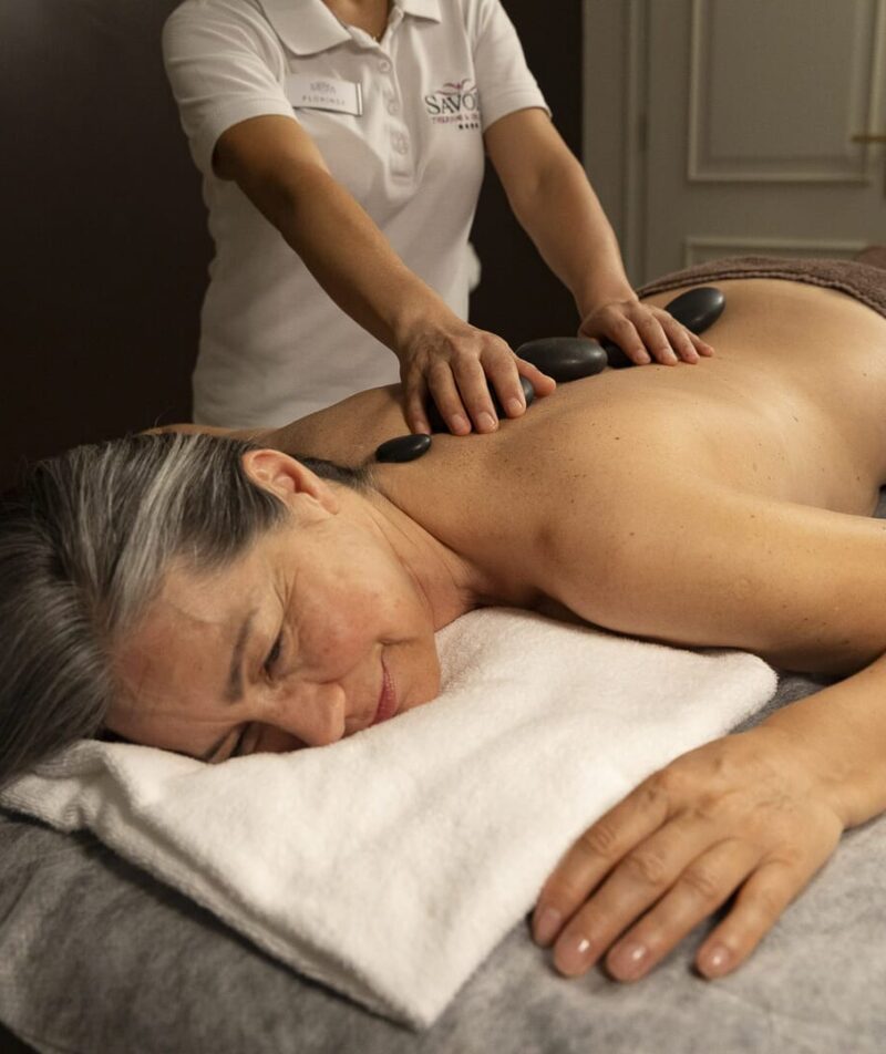 Heißsteinmassage bei einer entspannten Frau.