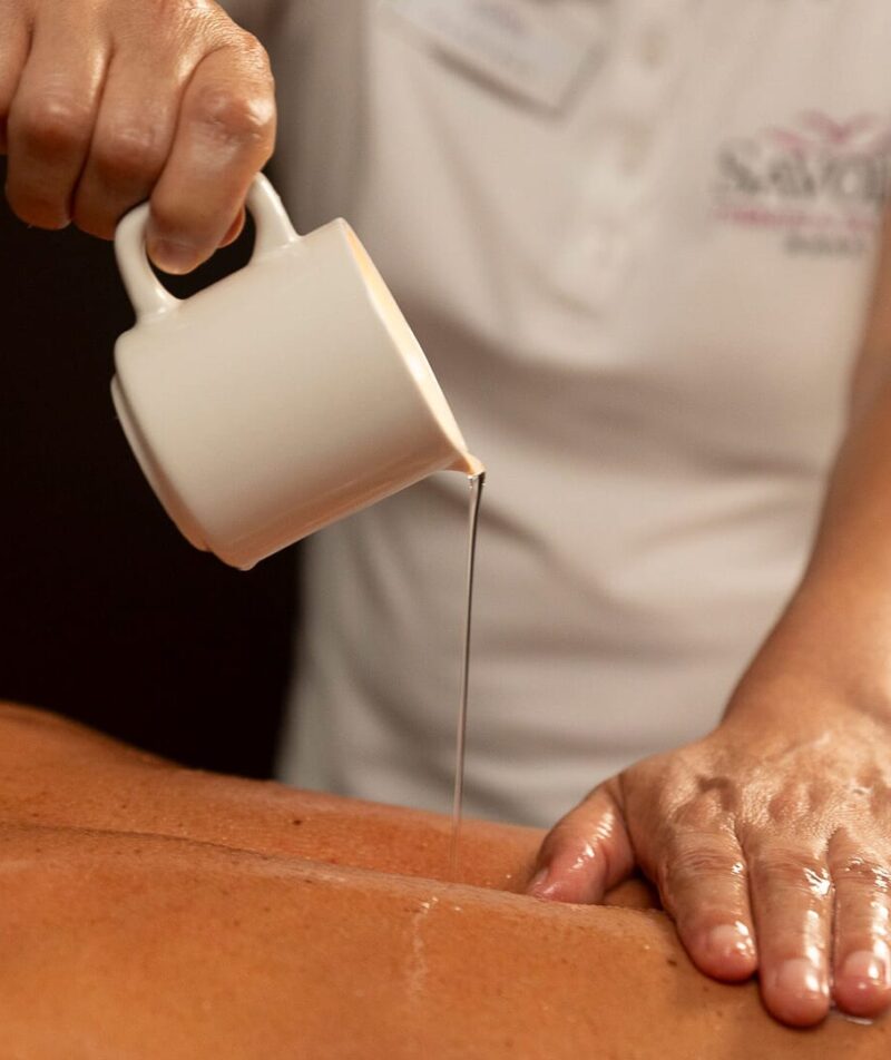Öl, das für eine entspannende Massage auf den Rücken aufgetragen wird.
