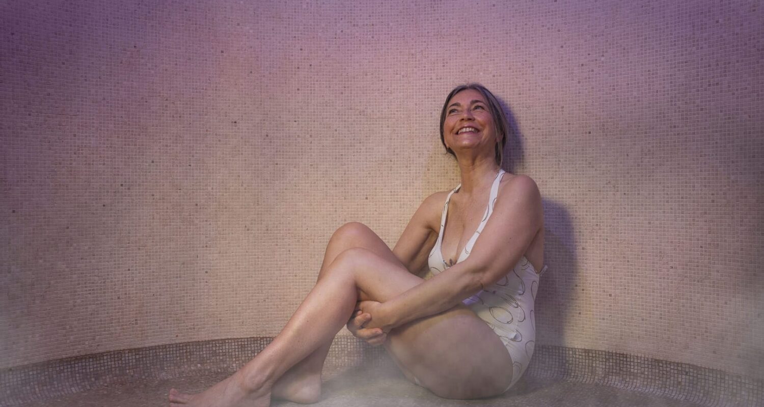 Donna felice nella sauna dell'hotel.