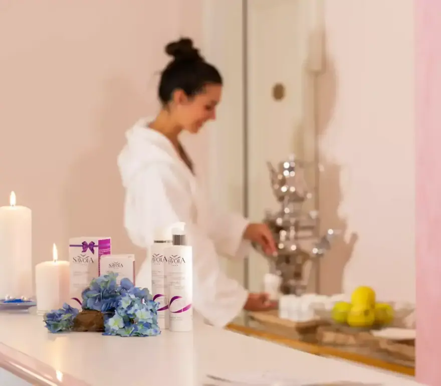 Frau im Spa mit Kerzen und Schönheitsprodukten.