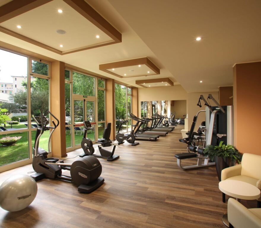 A modern gym with a view of the green garden.