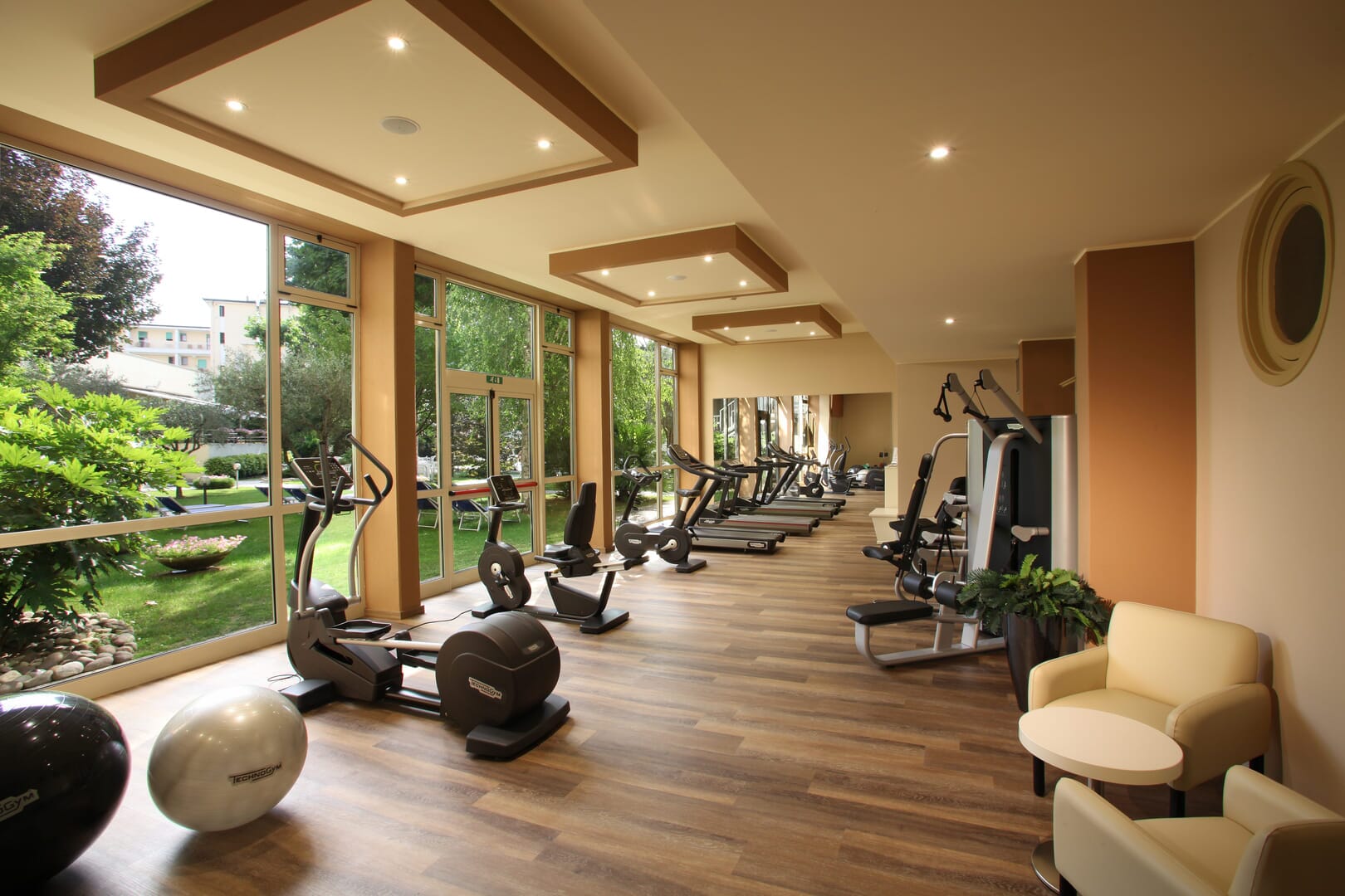 Ein modernes Fitnessstudio mit Blick auf einen grünen Garten.