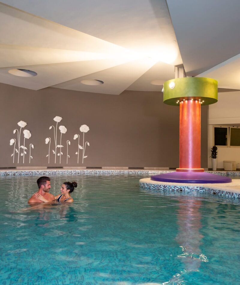 Indoor thermal pool with a happy couple.