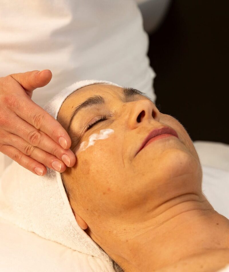 Eine Frau erhält eine Gesichtsbehandlung im Wellnesscenter.