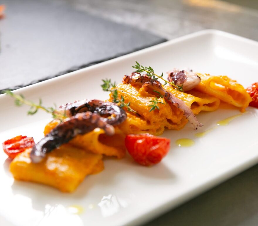 Pasta gourmet con pomodori e polpo.
