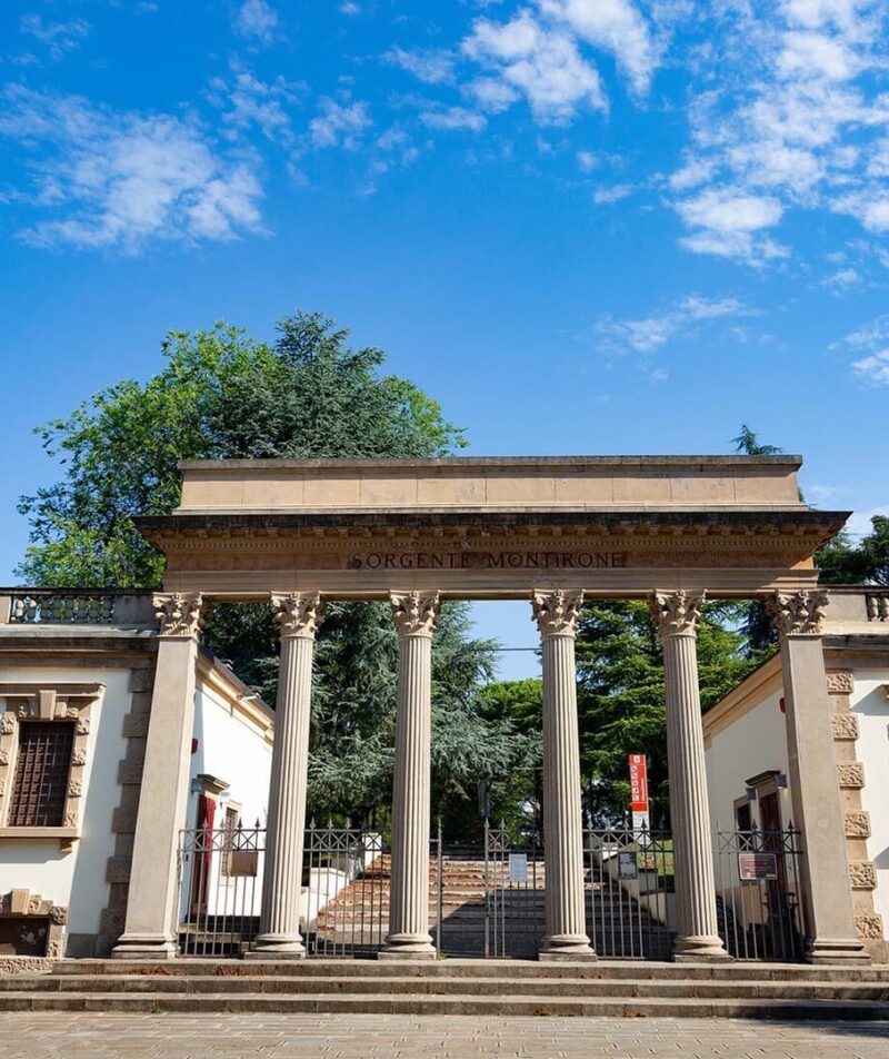 Edificio storico con colonne e cielo azzurro sopra.