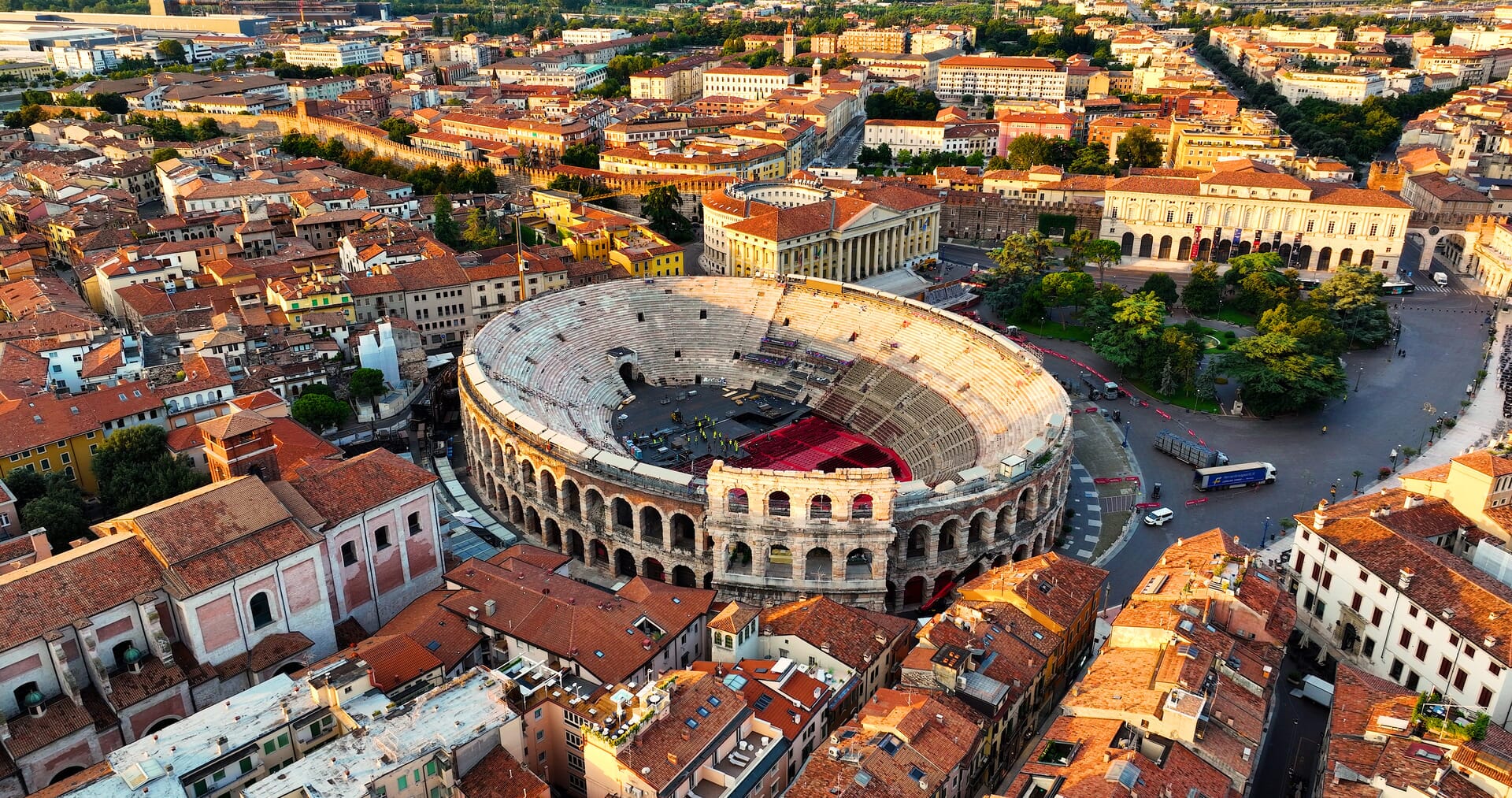 Anfiteatro romano e tetti rossi al tramonto.
